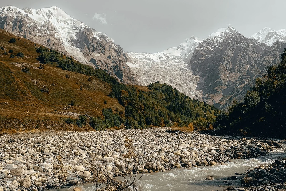 River flowing through valley toward snow-capped mountains near Ushguli, Svaneti