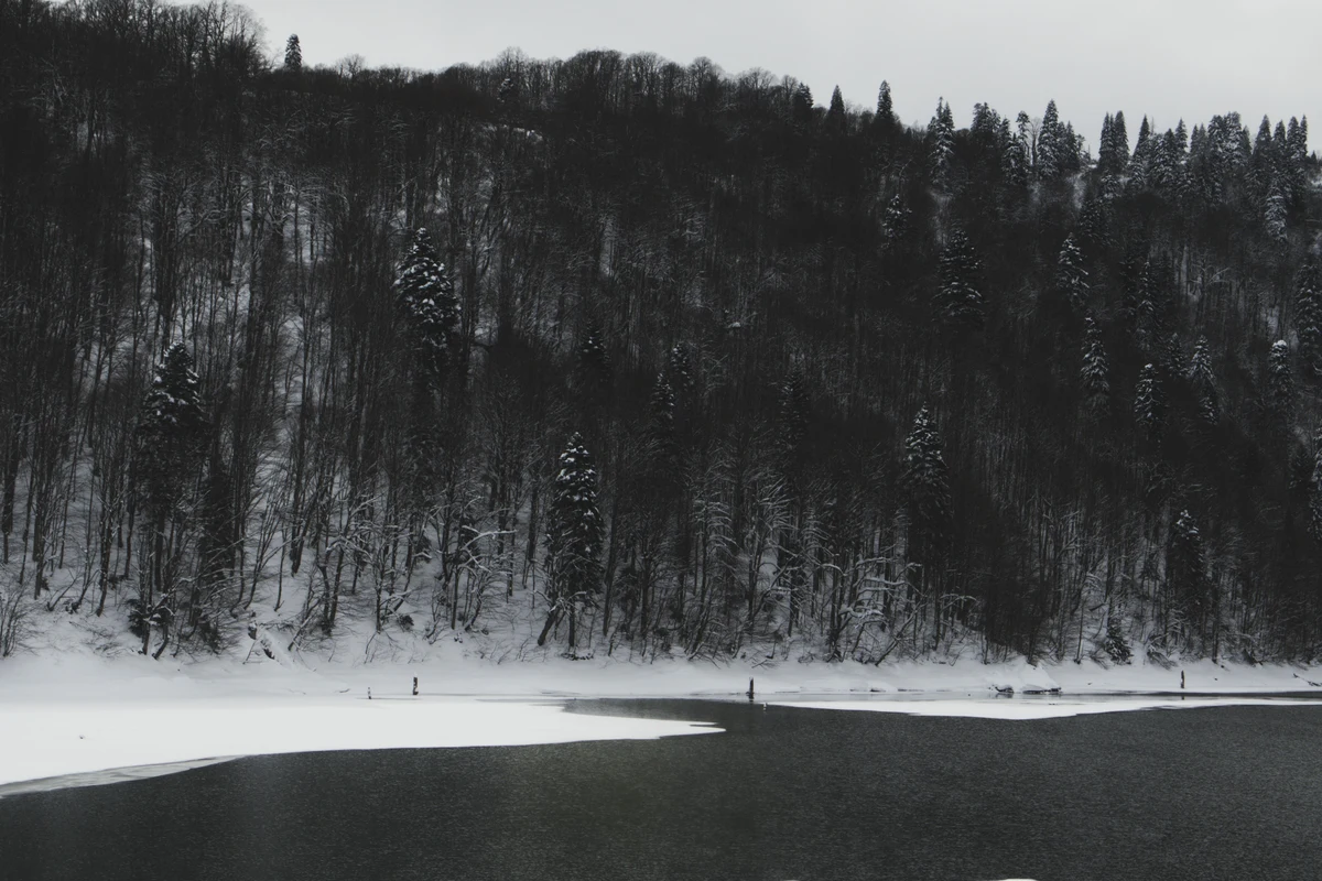 Snow-covered forest and frozen lake in Ambrolauri, Racha-Lechkhumi region of Georgia in winter — Tobavarchkhili Lakes are only accessible to trekkers from late June through September when the high passes are clear