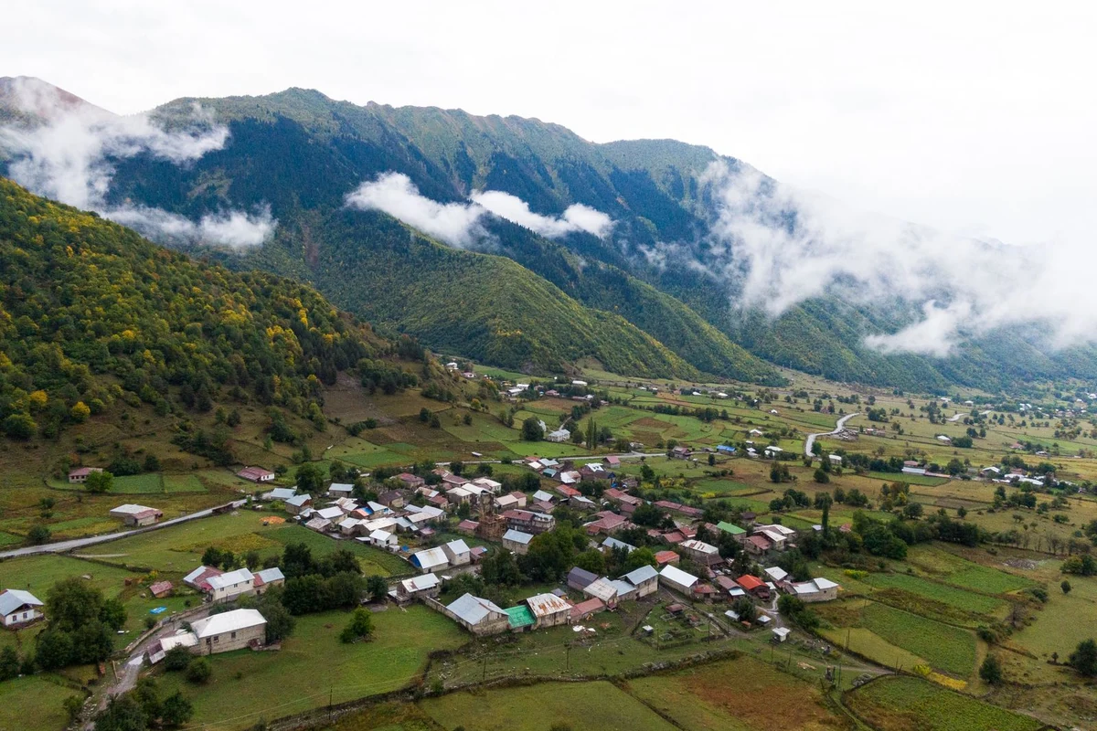 Aerial view of Mazeri village surrounded by misty mountain peaks, Svaneti