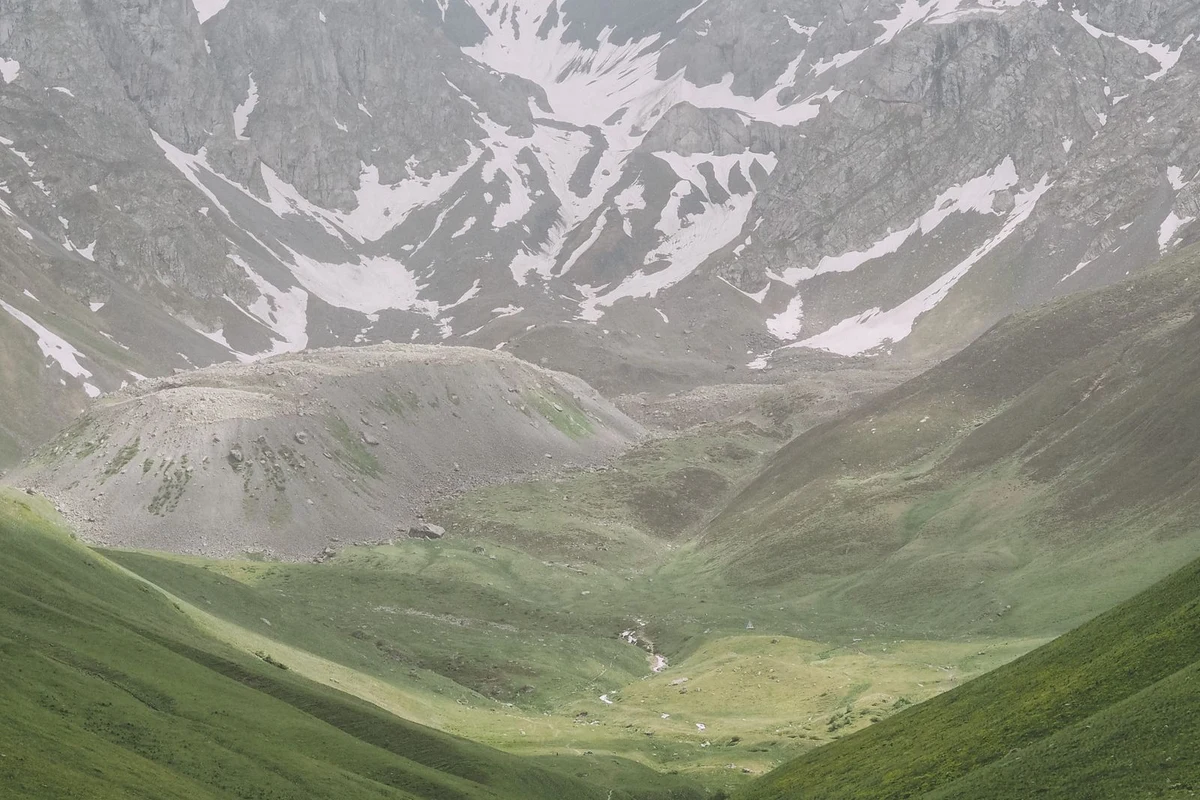Lush green highland valley with snow-capped peaks in Samegrelo, Georgia