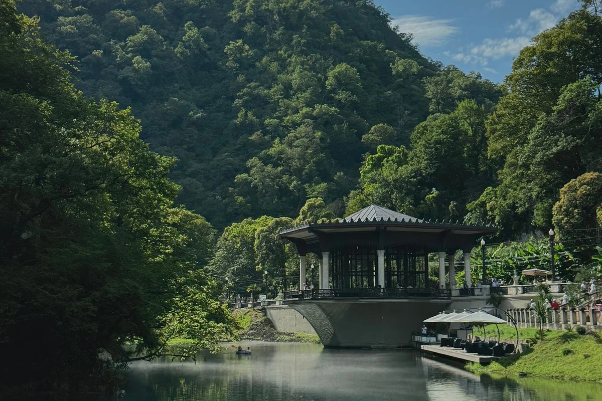 Traditional shelter by calm Lake Tobavarchkhili in lush mountain forest, Georgia